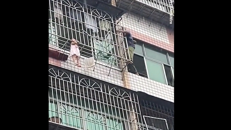 Маленькая девочка выпала из окна и повисла на 20-метровой высоте