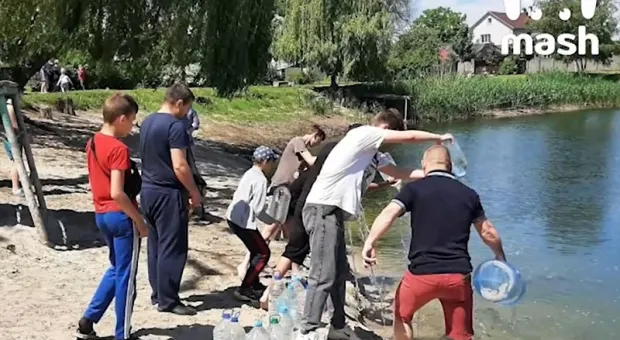 Жители спасают пруд, таская в него воду пятилитровыми баклажками